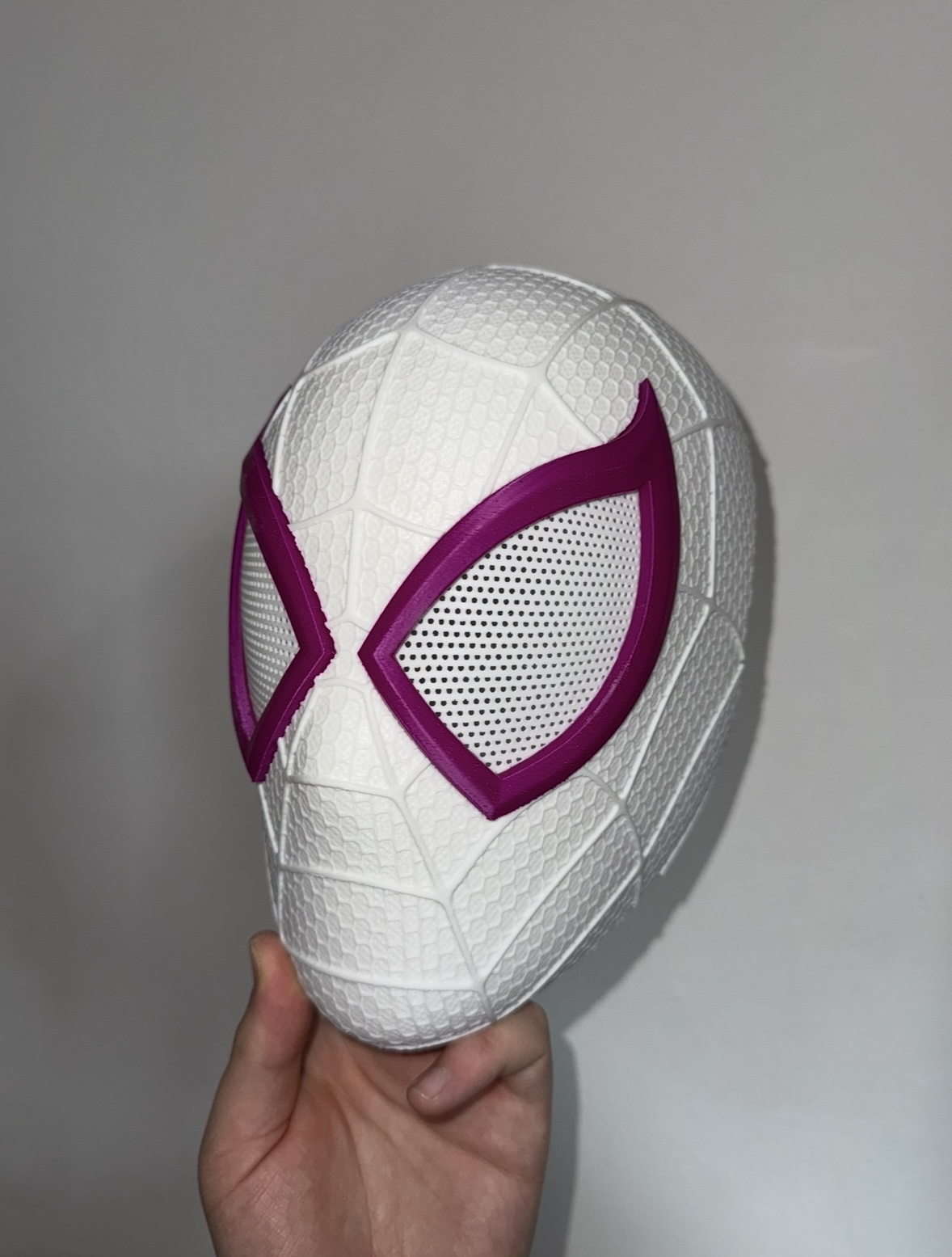 Small 3D printed helmet with a web design, white version, side view